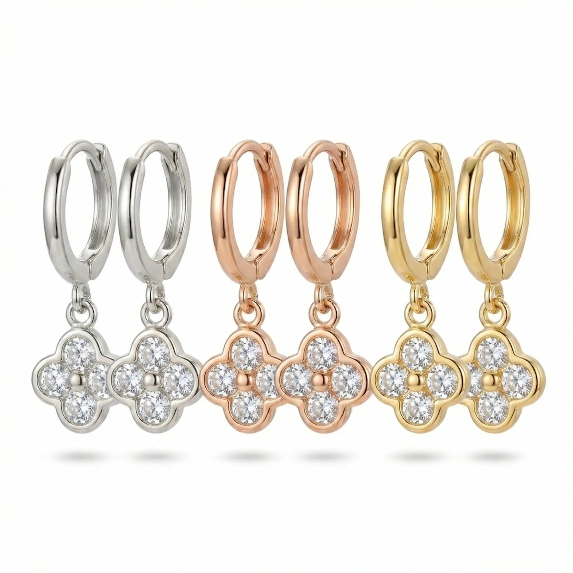 Three finishes of four-leaf clover huggie hoop earrings — silver, rose gold and gold, Luna Dura.