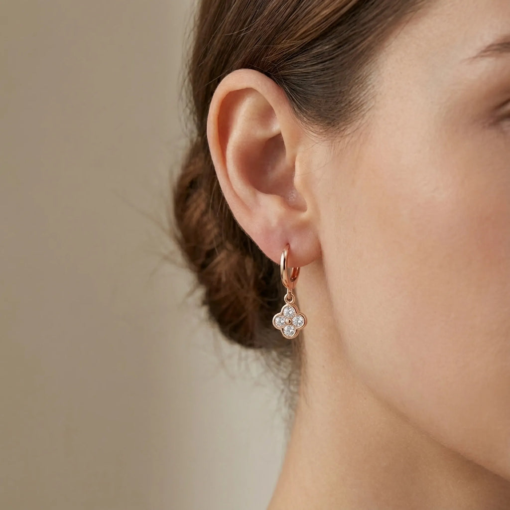 Woman wearing a rose gold four-leaf clover huggie hoop earring, Luna Dura Dubai.