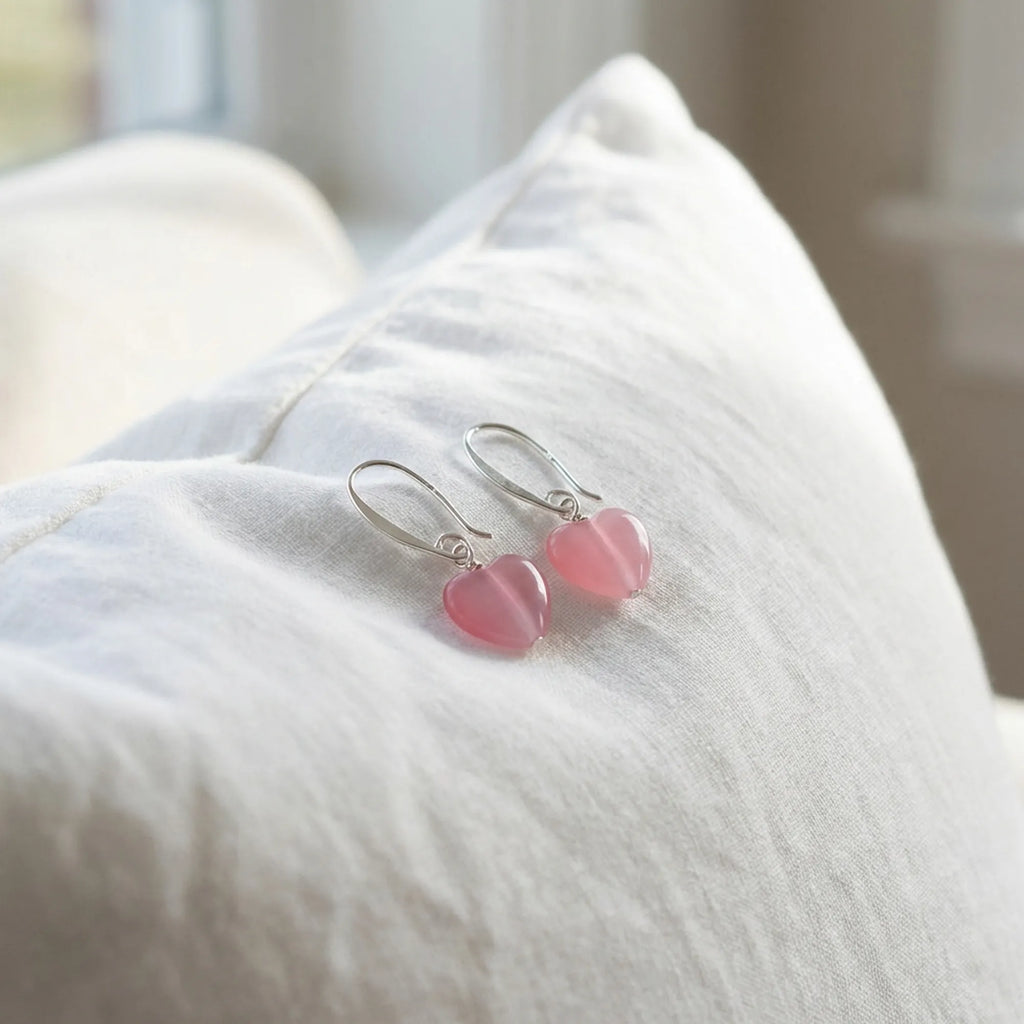 Pink heart silver drop earrings on white linen, soft-girl coquette styling, Luna Dura Dubai