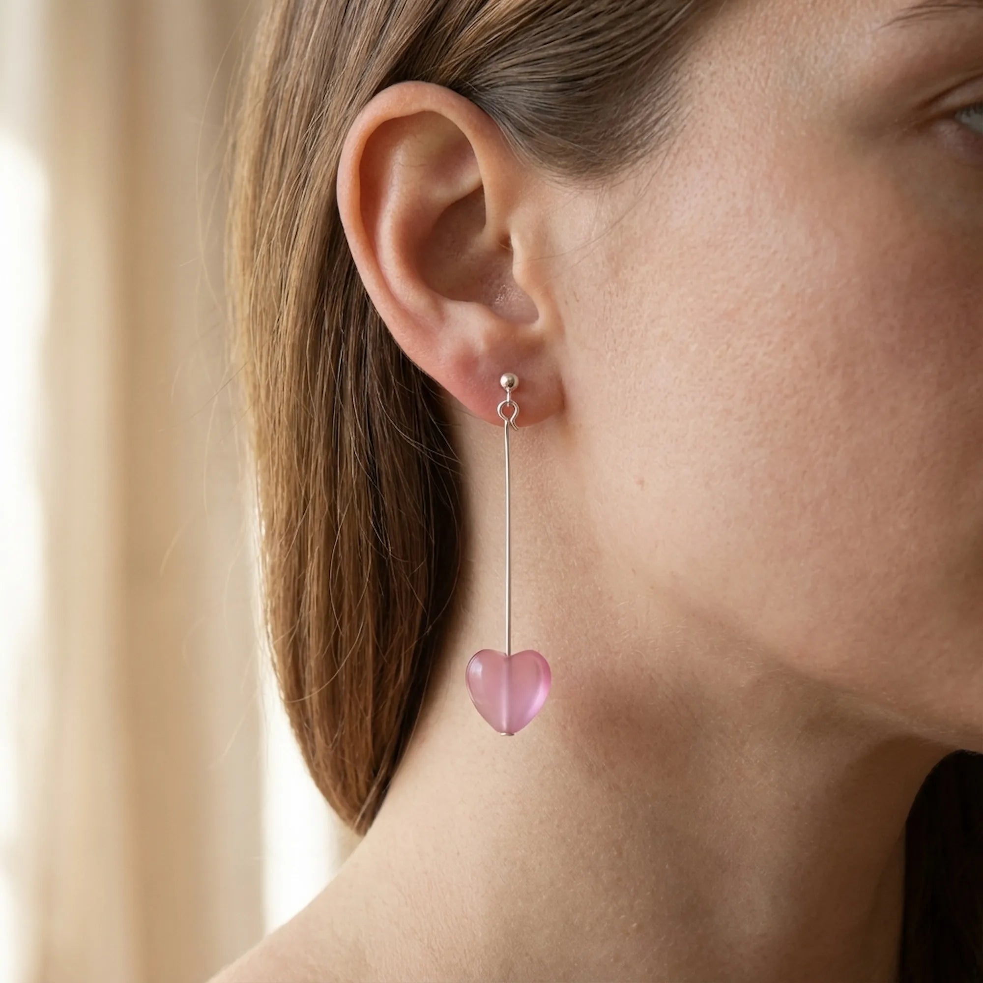 Frosted pink heart drop earring worn on the ear, 50 mm sterling silver bar drop, Dubai UAE