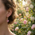 Frosted pink heart silver drop earring worn on the ear in a rose garden, French hook, Dubai UAE