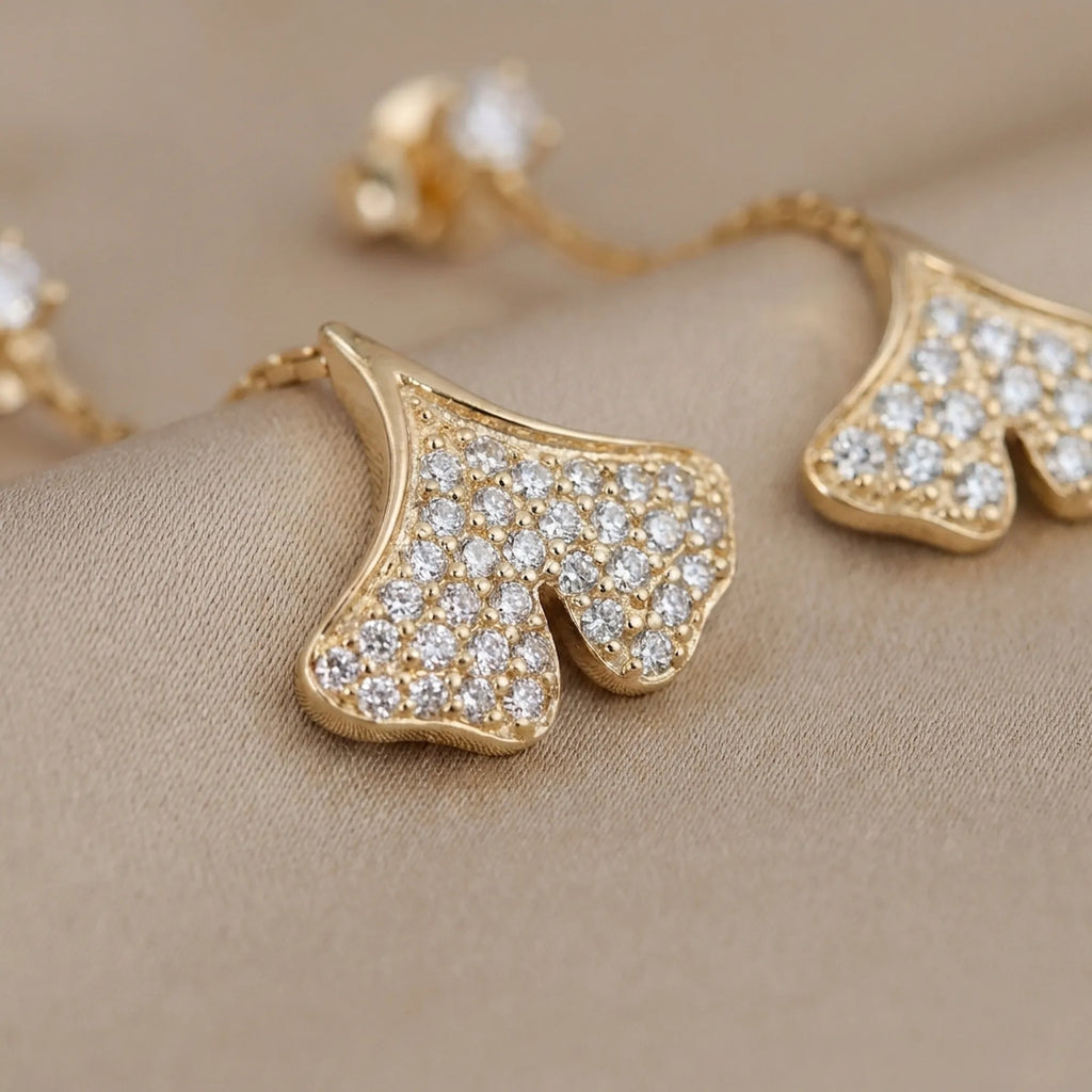 Macro close-up of pave CZ ginkgo leaf pendant in 18K gold showing individual round stone setting detail