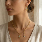 Gold Hamsa necklace and huggie earring worn on model, mixed-link chain with evil eye charm, Dubai UAE
