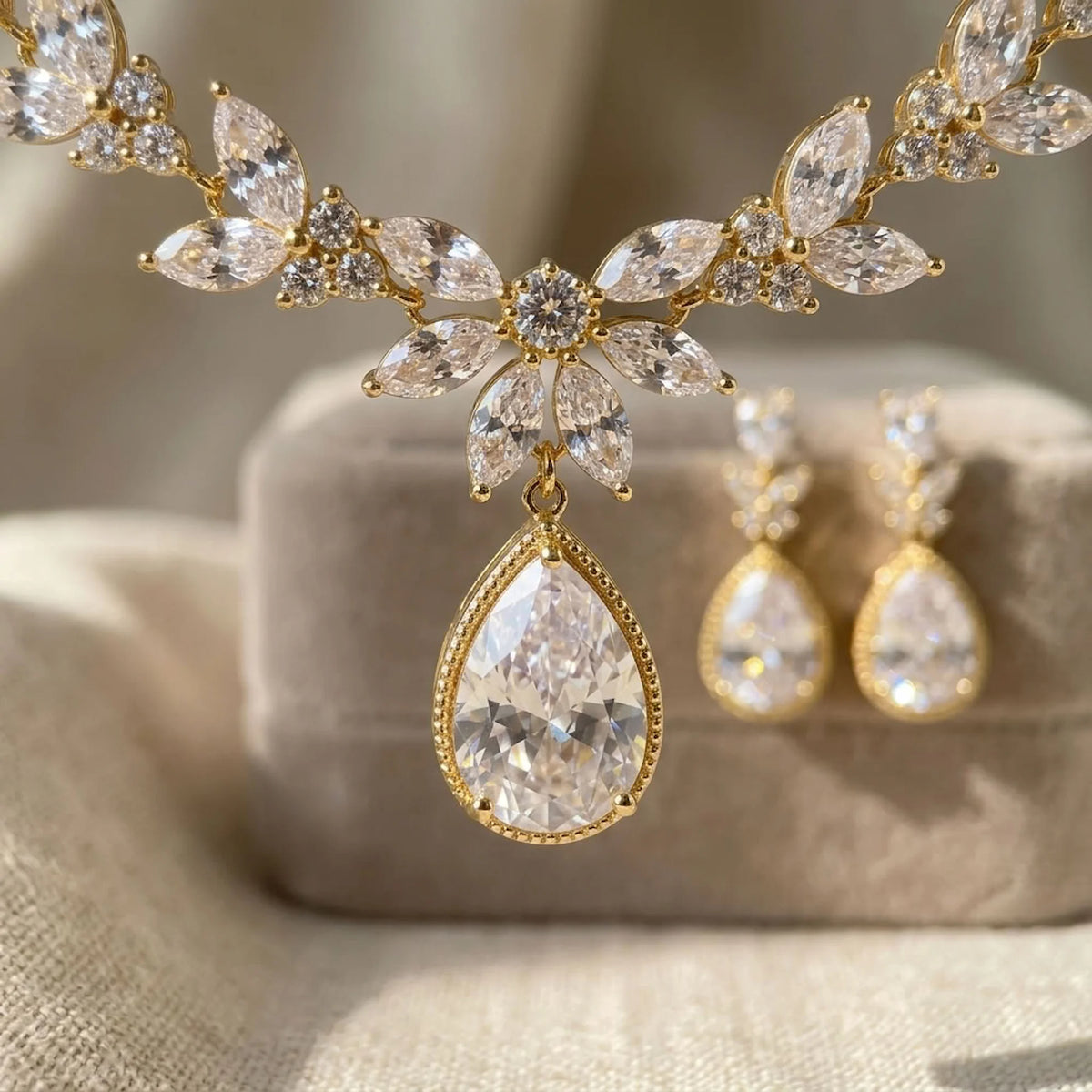 Macro view of an 18k gold-plated halo pear teardrop pendant with marquise leaf accents resting on velvet in Dubai.