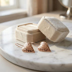 Hammered rose gold heart drop earrings beside cream velvet jewelry box on marble — romantic gift earrings Dubai UAE