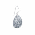 Single hammered teardrop 925 sterling silver drop earring with shepherd hook on a white background in Dubai.
