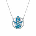 Hamsa hand pendant necklace in 925 sterling silver with powder blue enamel and a sky blue topaz eye, Luna Dura Dubai.