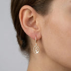 Gold plated Hamsa oval drop earring on ear — 18K gold over 925 sterling silver with pavé CZ lever-back