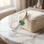 Teal enamel Hamsa bangle leaning against cream velvet jewelry gift box on marble table, Dubai gifting
