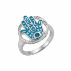 Sterling silver hamsa ring with powder blue enamel and a faceted blue topaz eye on a white background UAE.