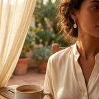 Woman wearing Hamsa rose gold drop earrings in warm afternoon light — protective Hand of Fatima jewelry Dubai