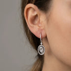 Silver rhodium Hamsa drop earring on ear — 925 sterling silver with pavé cubic zirconia oval frame