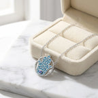 Azure blue Hamsa tanzanite pendant necklace in a cream velvet gift box, 925 sterling silver, Luna Dura Dubai.