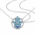 Hamsa hand pendant necklace in 925 sterling silver with azure blue enamel and a natural tanzanite eye, Luna Dura Dubai.