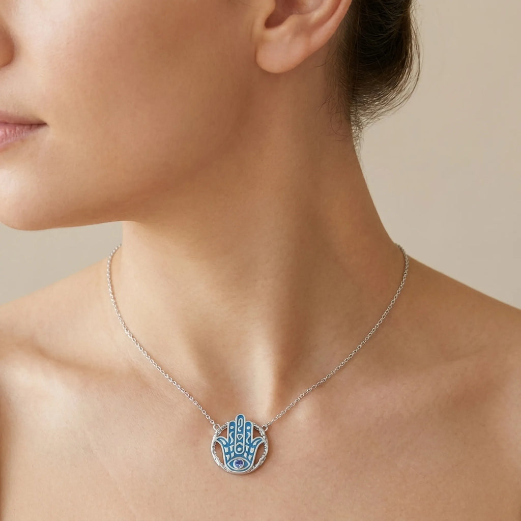 Woman wearing an azure blue Hamsa pendant necklace with a tanzanite eye in 925 silver, Luna Dura Dubai.
