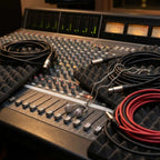 CZ headphone pendant necklace on thick silver chain placed on professional recording console with XLR cables and faders UAE