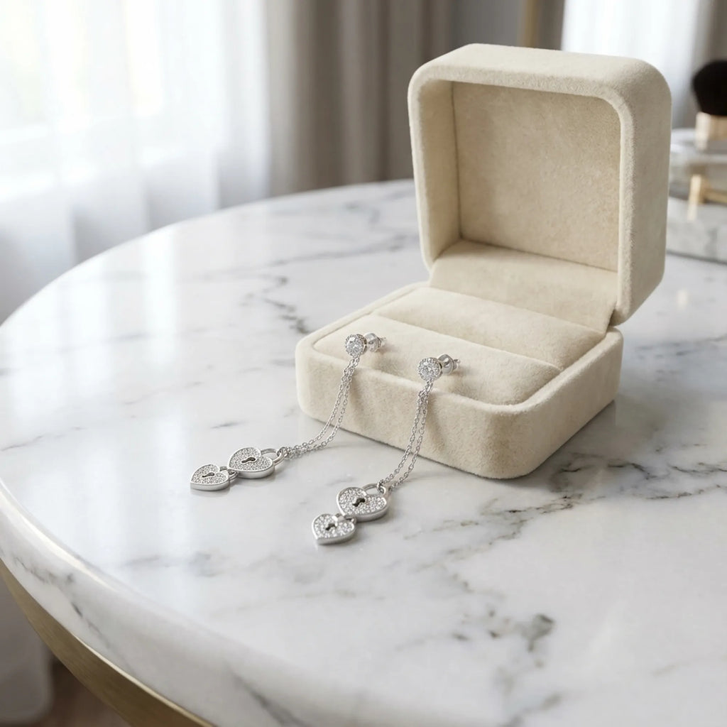 Heart lock drop earrings in open cream velvet jewelry box on marble — rhodium 925 silver pavé CZ coquette gift earrings Dubai UAE