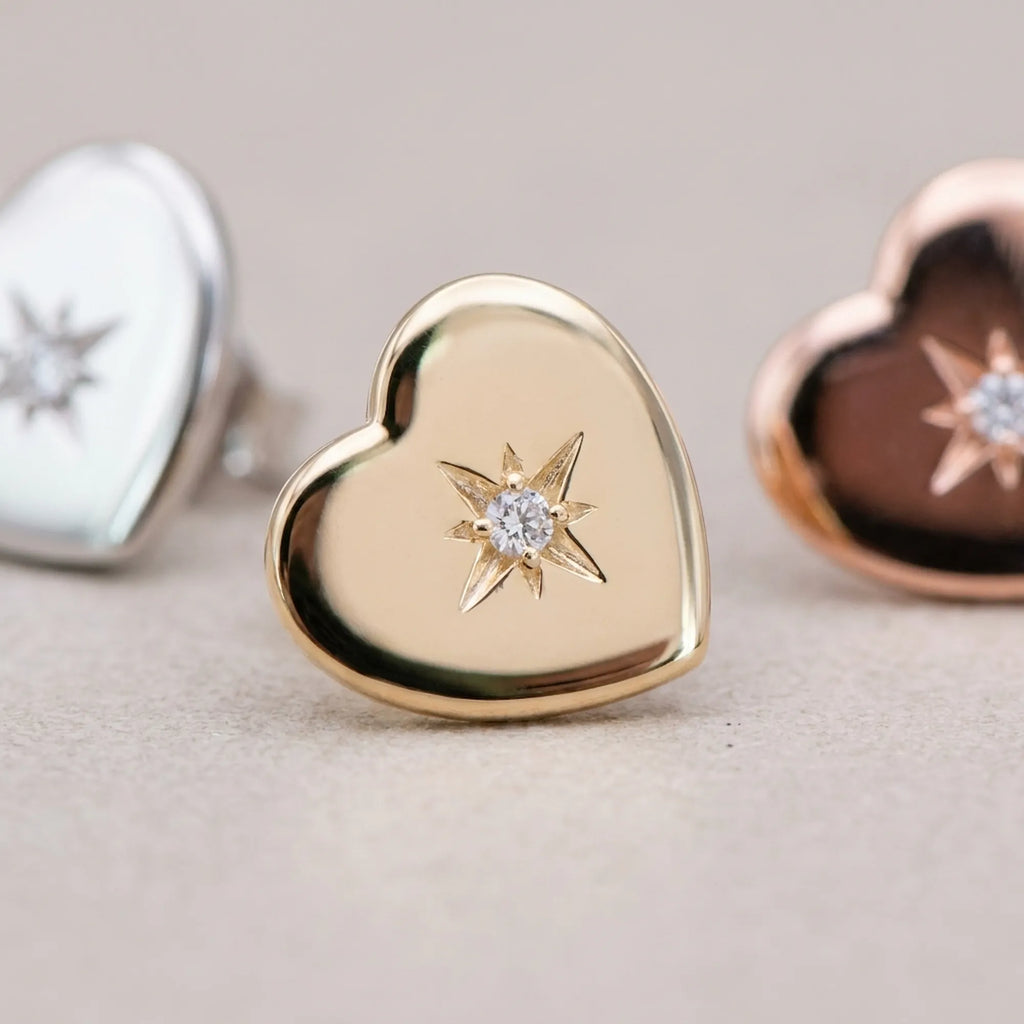 North star CZ engraving on gold heart stud earring with silver and rose gold variants in background — 925 sterling silver