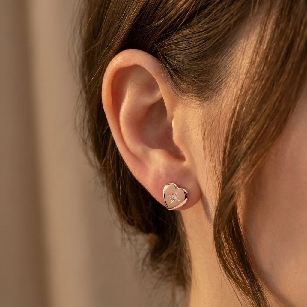 Hiam rose gold heart stud earring worn on ear — 18K rose gold plated 925 silver, north star CZ engraving