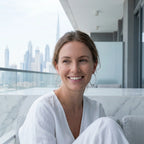 Woman wearing 2-in-1 silver hoop earrings with CZ bead on balcony with Burj Khalifa and Downtown Dubai skyline behind