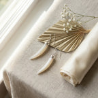 Mother of pearl horn dangle earrings on linen with dried palm — 925 silver, natural stone lifestyle flat lay