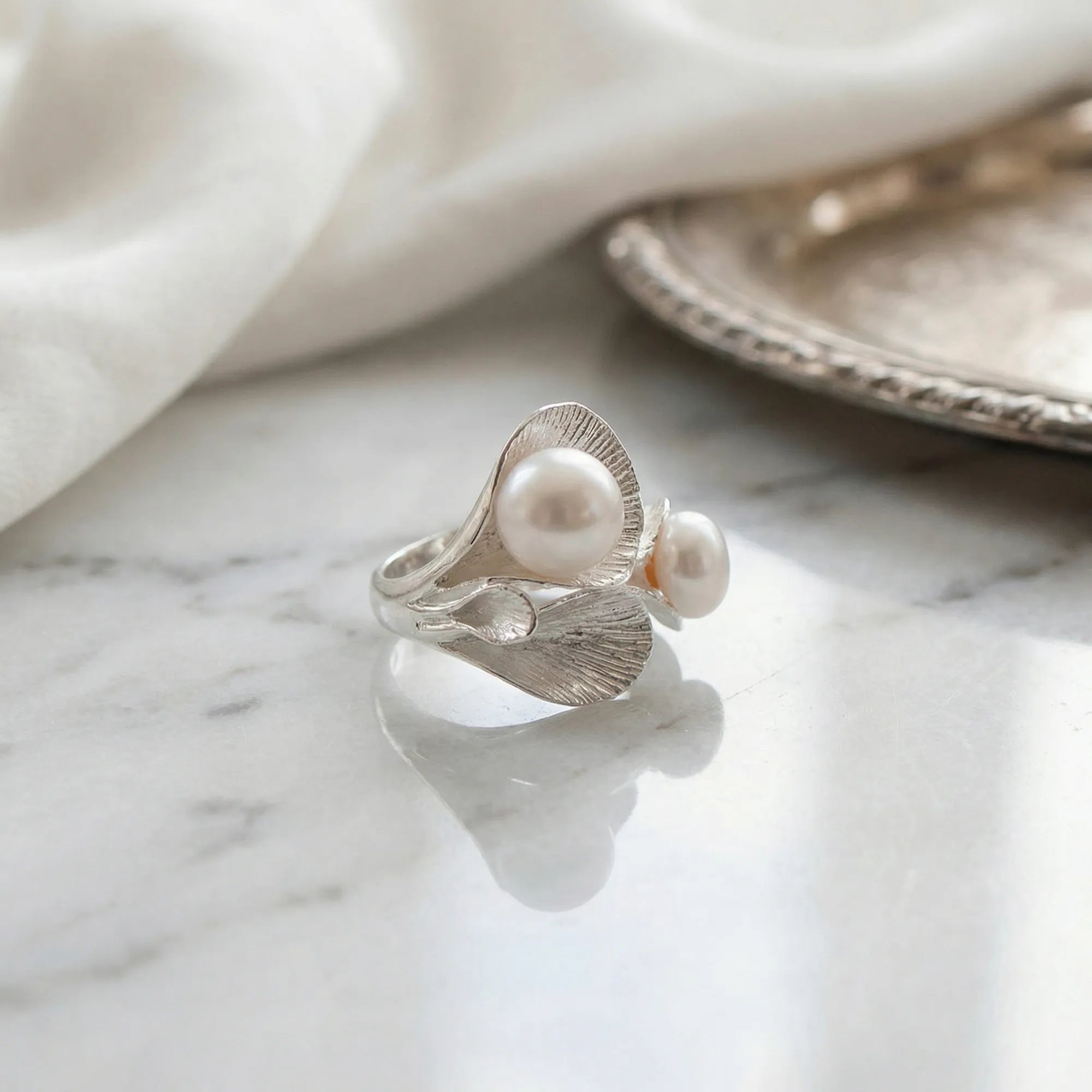 Hosta leaf twin pearl ring in 925 silver on marble surface, lifestyle shot, Dubai