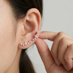 Close up of a woman easily adjusting the stackable rose gold ear cuff, demonstrating how it sweeps securely up the ear.
