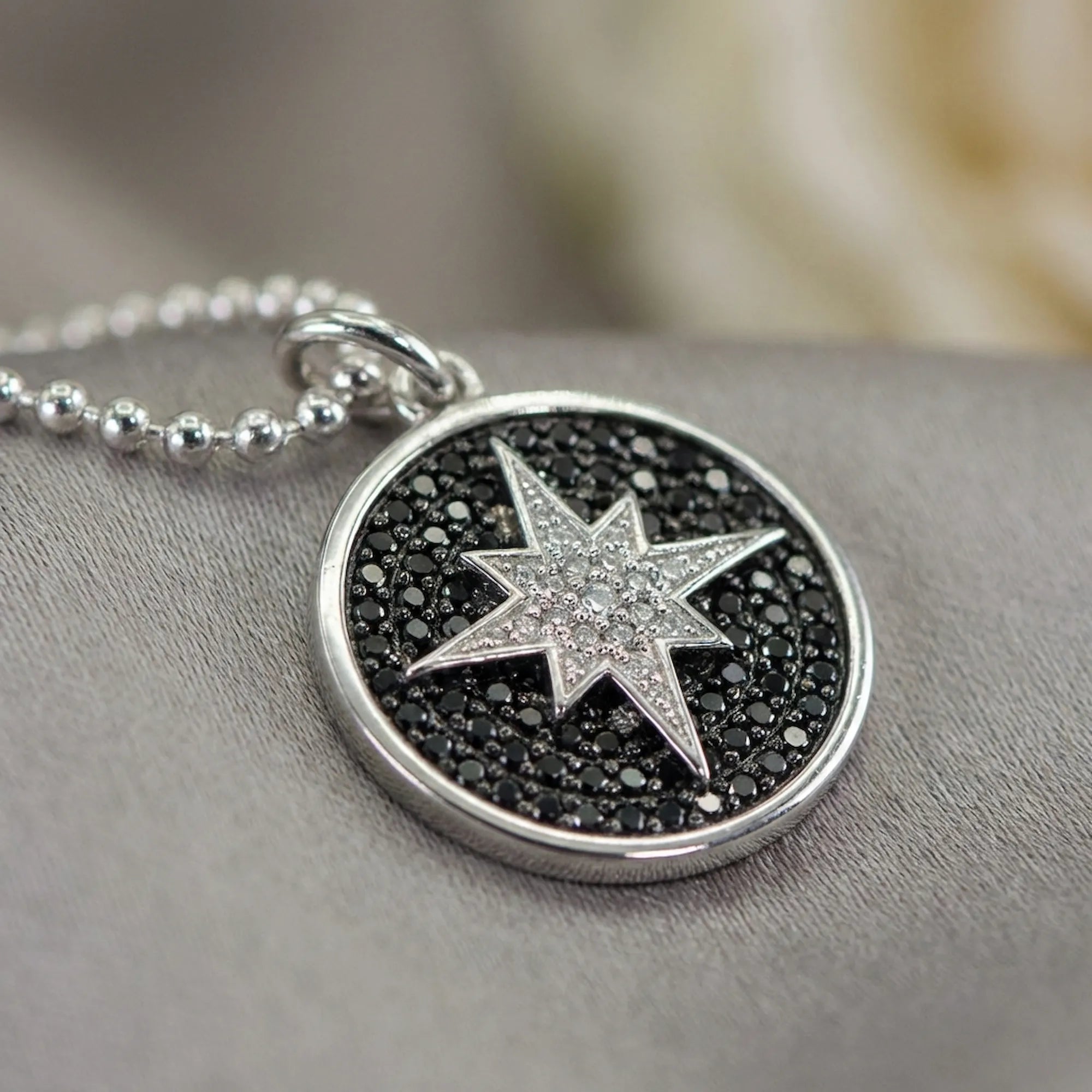 Close-up macro shot highlighting the intricate full pave black and white CZ setting on the sterling silver star pendant jewelry dubai.