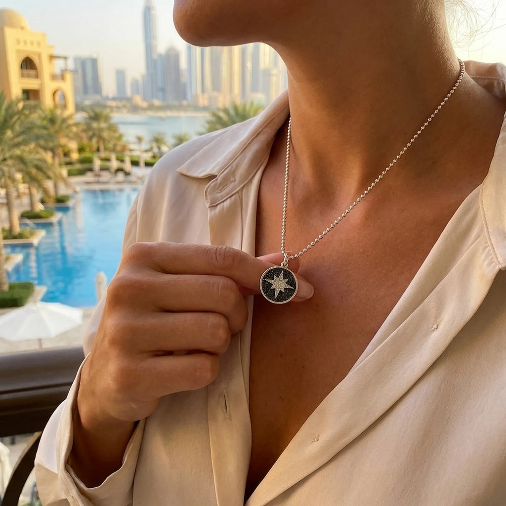 Woman wearing the elegant black and white CZ star necklace against a sunny Dubai skyline, perfect for everyday luxury jewelry dubai styling.