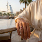 Elegant woman wearing the Lab Grown Padparadscha Sapphire Ring while relaxing in Dubai, highlighting luxury jewelry styling.