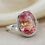 Close-up macro shot revealing the flawless clarity, vibrant pink-orange color mix, and expert faceting of the lab grown padparadscha sapphire.