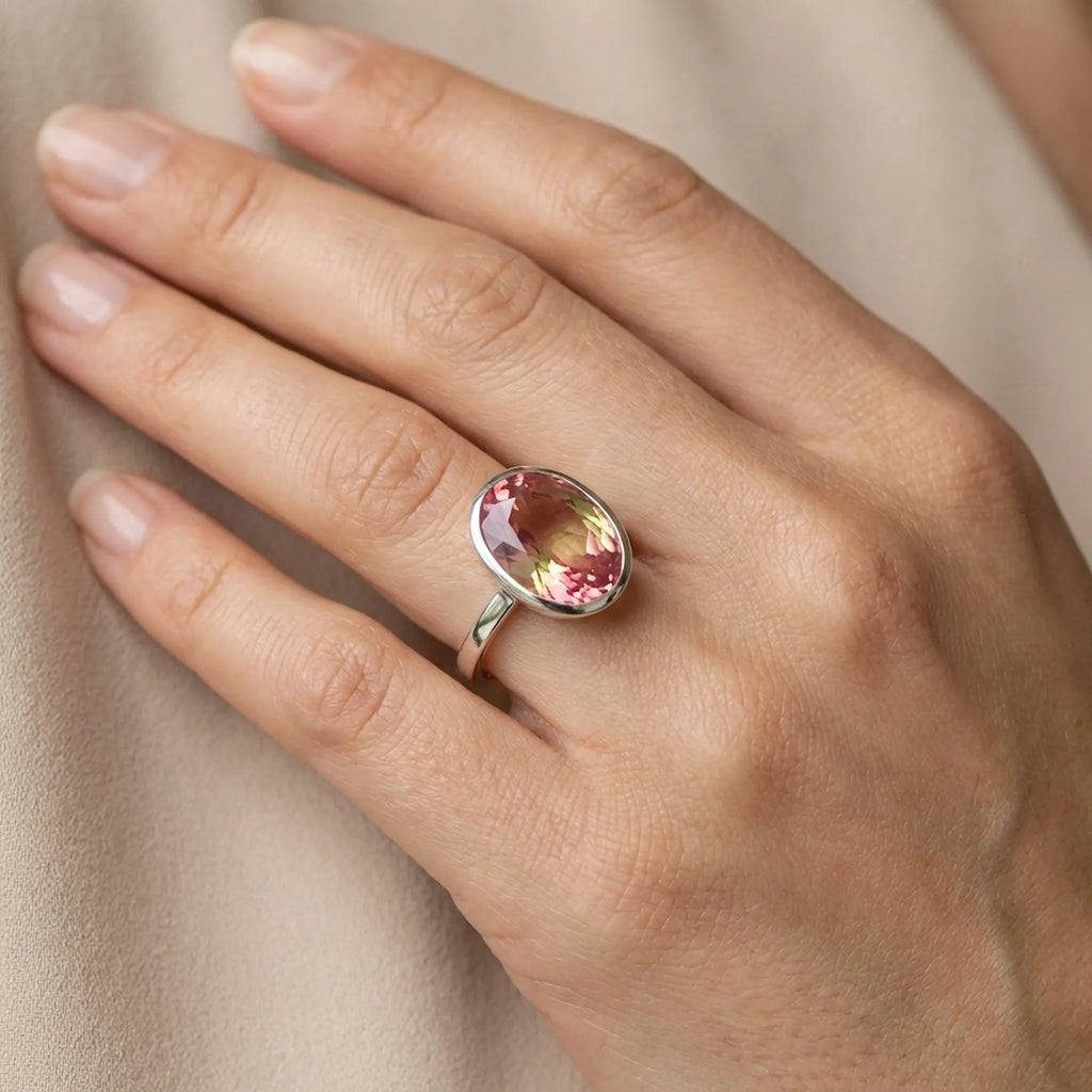 Model wearing the Lab Grown Padparadscha Sapphire Ring on her hand to demonstrate the 11.45-carat gemstone size and 2mm flat band fit.