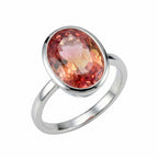 Front view of the Lab Grown Padparadscha Sapphire Ring featuring an 11.45-carat oval cut gemstone in a 925 silver bezel setting.