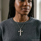 Woman wearing a polished sterling silver cross pendant with three raised dot accents, chain not included.