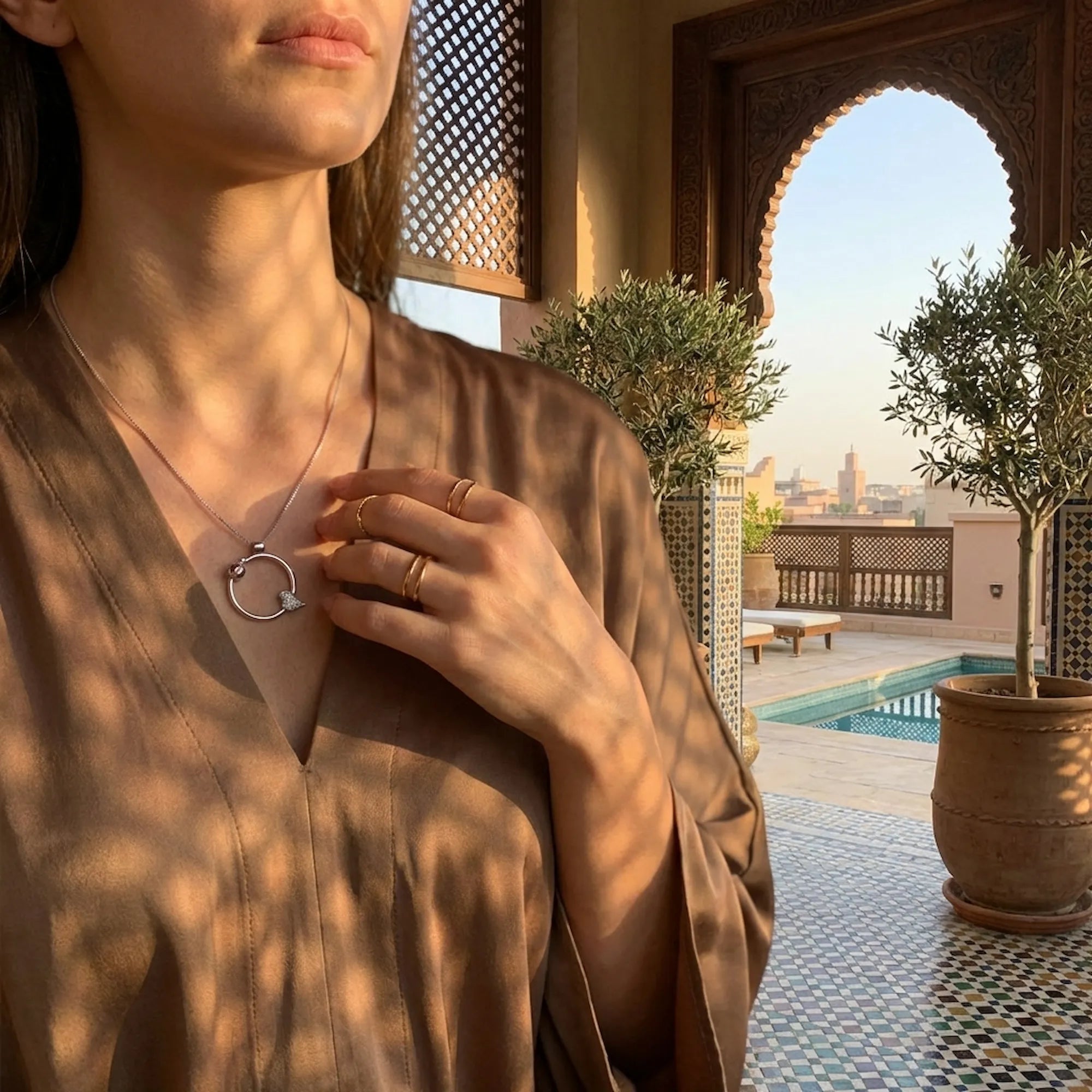 Woman in an elegant outdoor setting wearing the fashion 2026 ladybug necklace for everyday luxury.