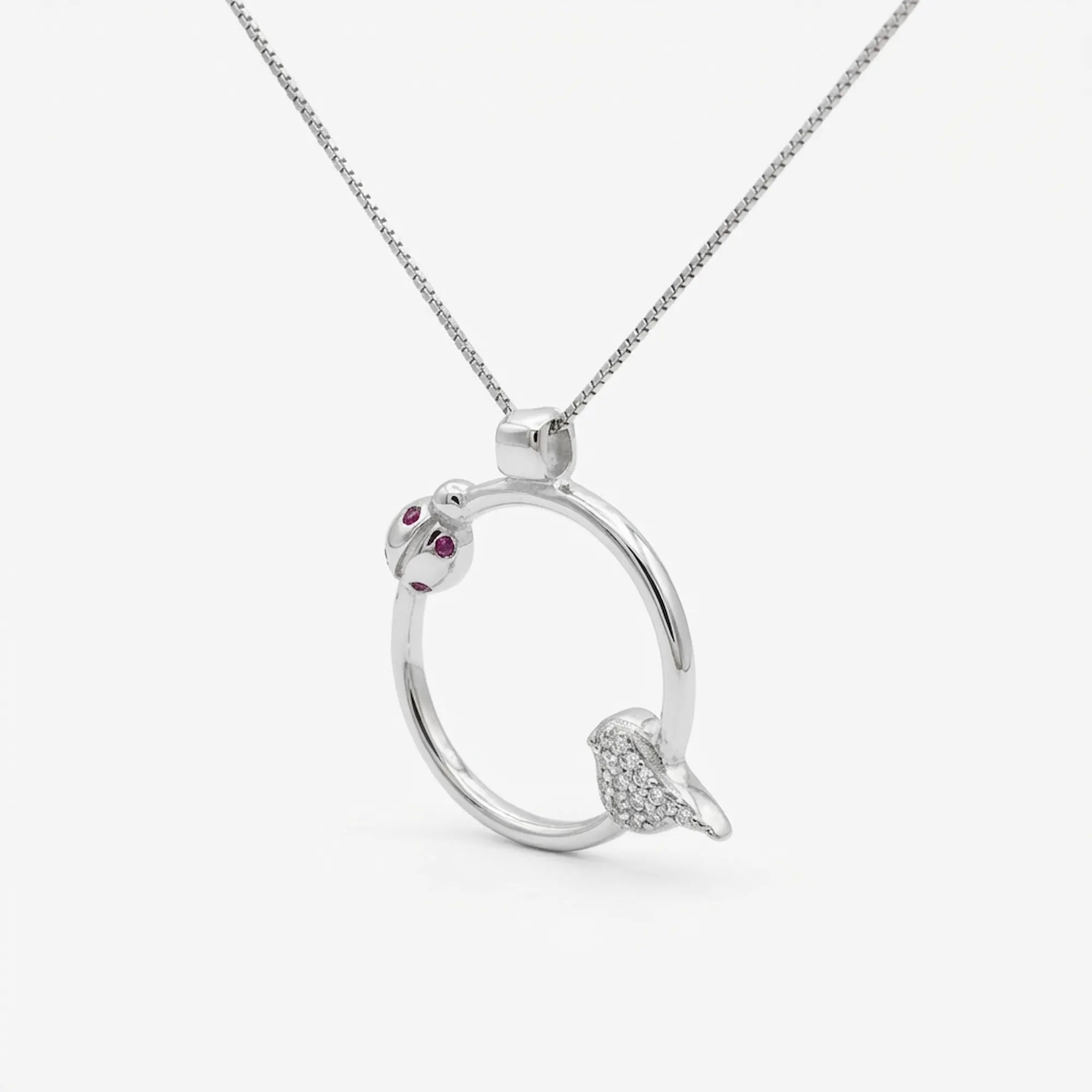 Forty-five degree angle of the rhodium plated ladybug necklace highlighting the spring design bird charm