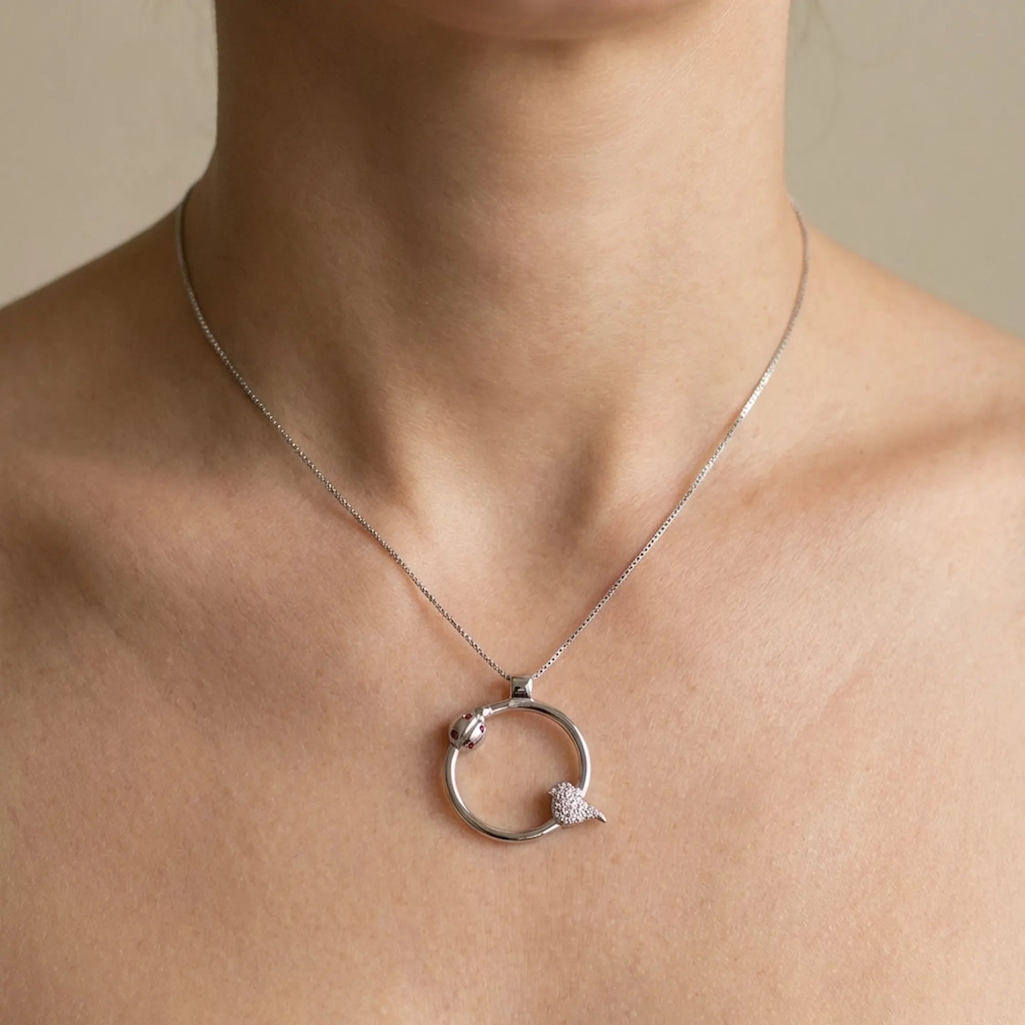 Model wearing the ladybug necklace demonstrating the 19.8mm charm size and fit on the collarbone.