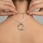 Close up of a woman fastening the secure spring lock clasp on the back of the ladybug necklace.