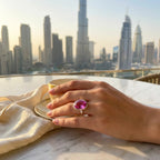 Woman wearing the Large Oval Pink Purple Quartz Ring while enjoying a coffee with the stunning Dubai downtown skyline in the background.