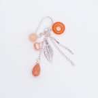 Detailed flat lay view revealing the intricate layers of our 925 sterling silver leaf chain drop earrings with matte peach stones.