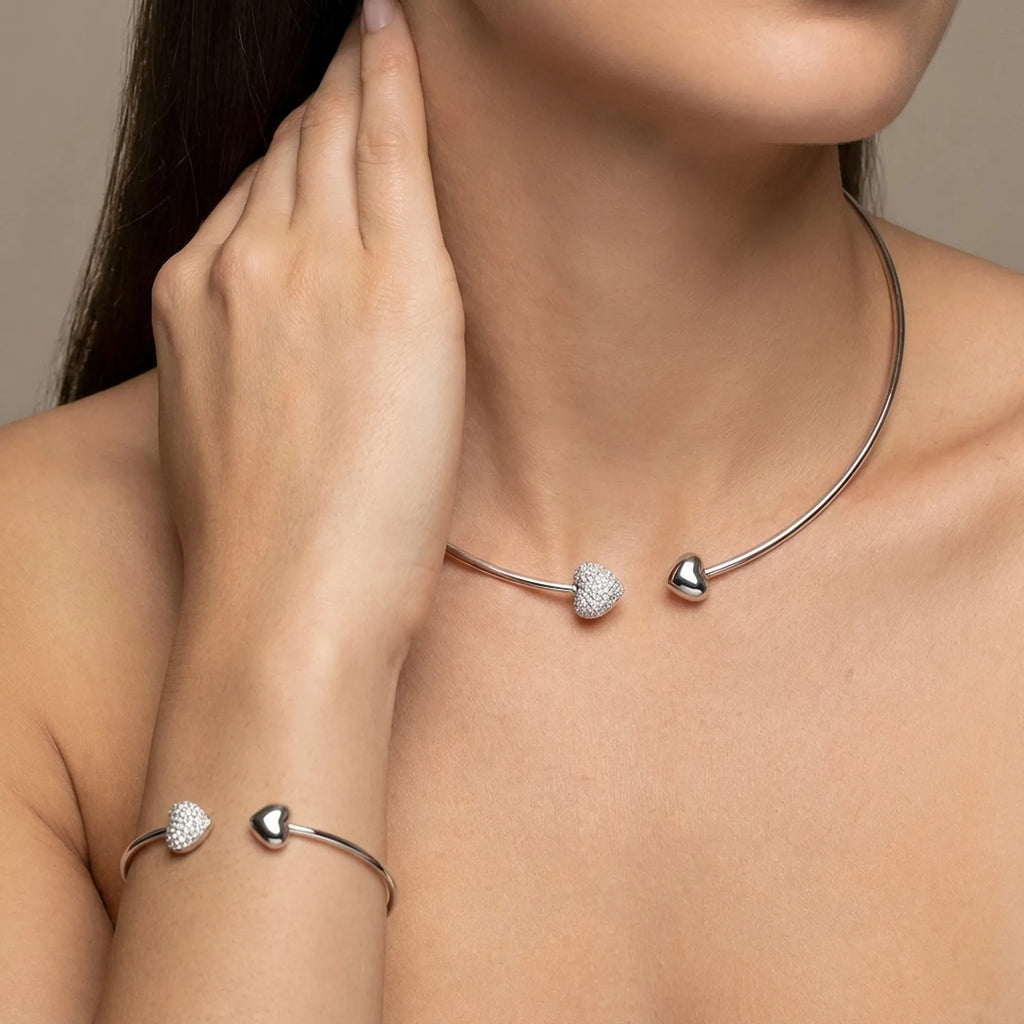 Elegant woman wearing the minimalist open tube choker necklace and matching bangle set against a soft, neutral beige background.