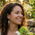 A woman smiling outdoors wearing our bohemian 925 sterling silver leaf chain drop earrings styled with vibrant lime green natural stones.