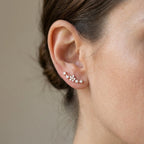 A woman wearing the 21mm long lightweight plume earrings, demonstrating the perfect scale and fit as it rests along the earlobe.