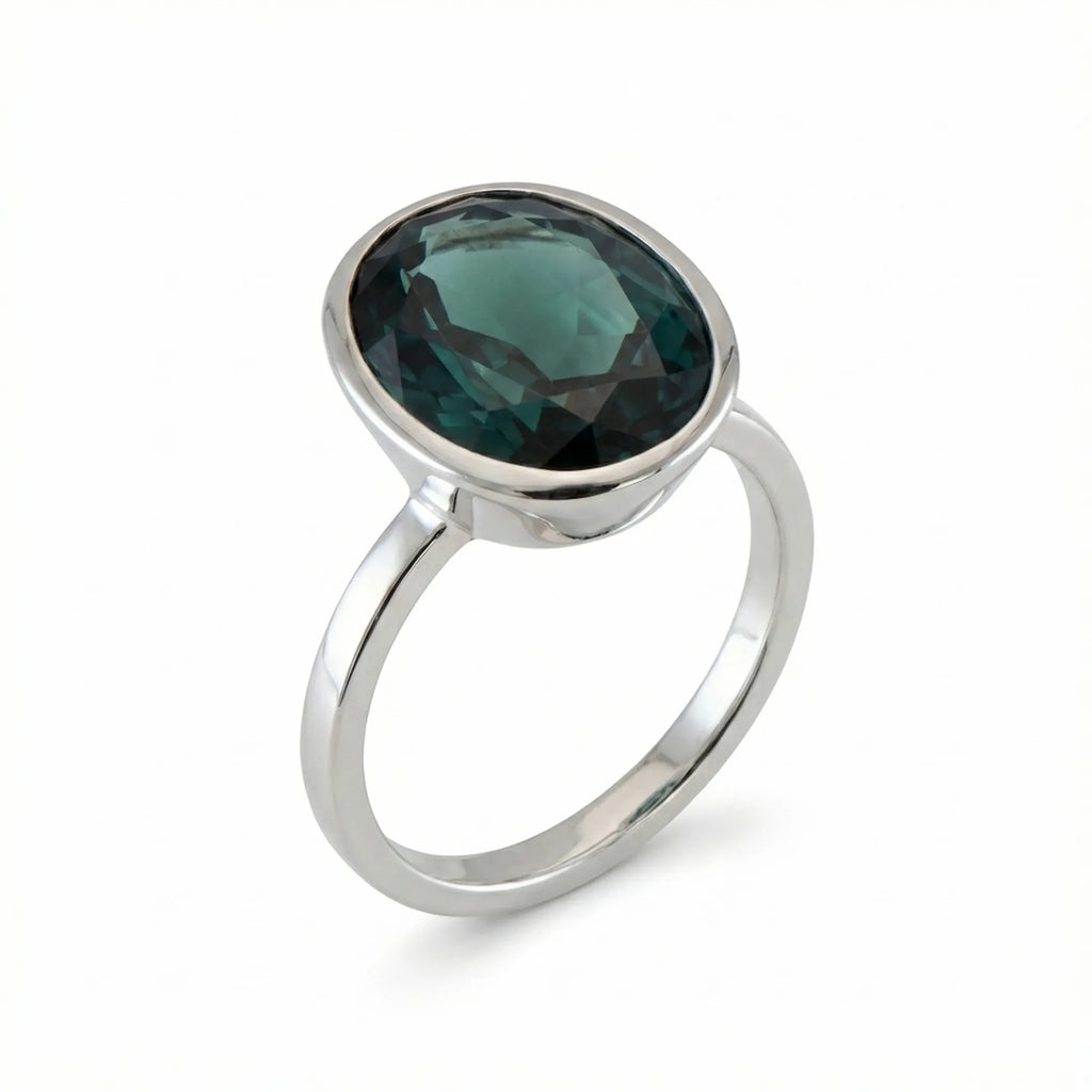 Discover our stackable London Blue Topaz ring featuring a deep teal oval gemstone in a snag-free 925 sterling silver bezel setting.