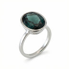 Discover our stackable London Blue Topaz ring featuring a deep teal oval gemstone in a snag-free 925 sterling silver bezel setting.