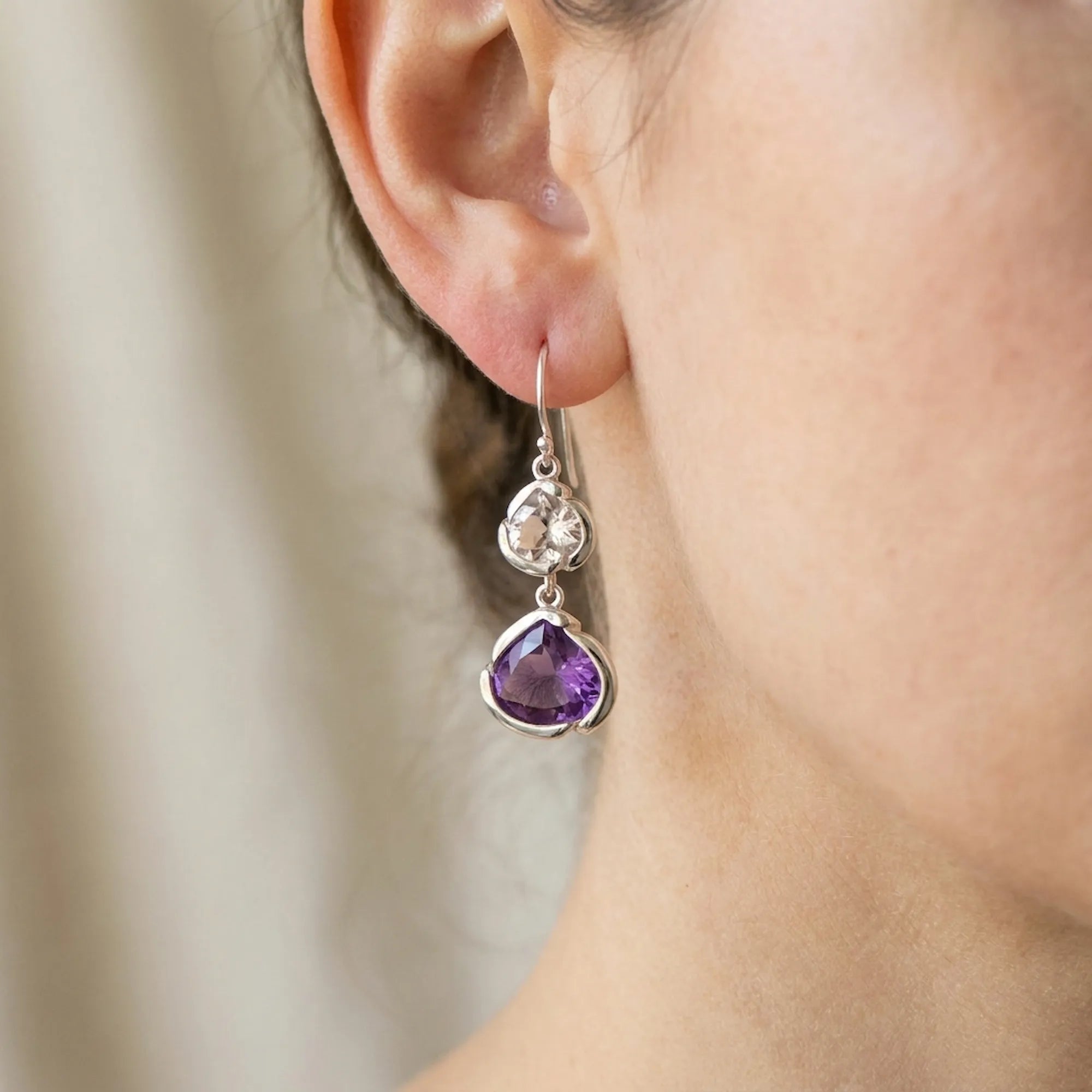 Close-up of an amethyst and white topaz lotus drop earring in 925 silver, Luna Dura.