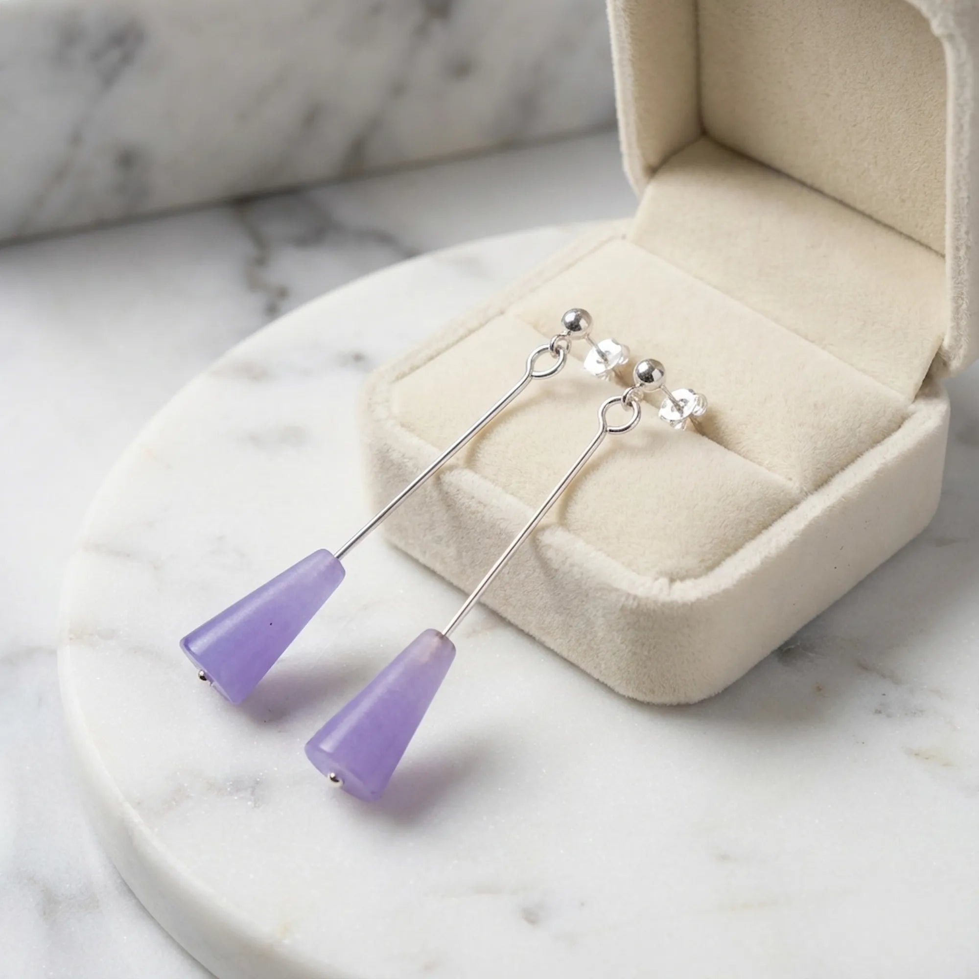 Amethyst purple lucite cone drop earrings on marble dish with jewelry box — geometric drop earrings gift UAE