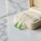 Sage green lucite cone drop earrings in cream velvet jewelry box on marble — minimalist gift earrings Dubai