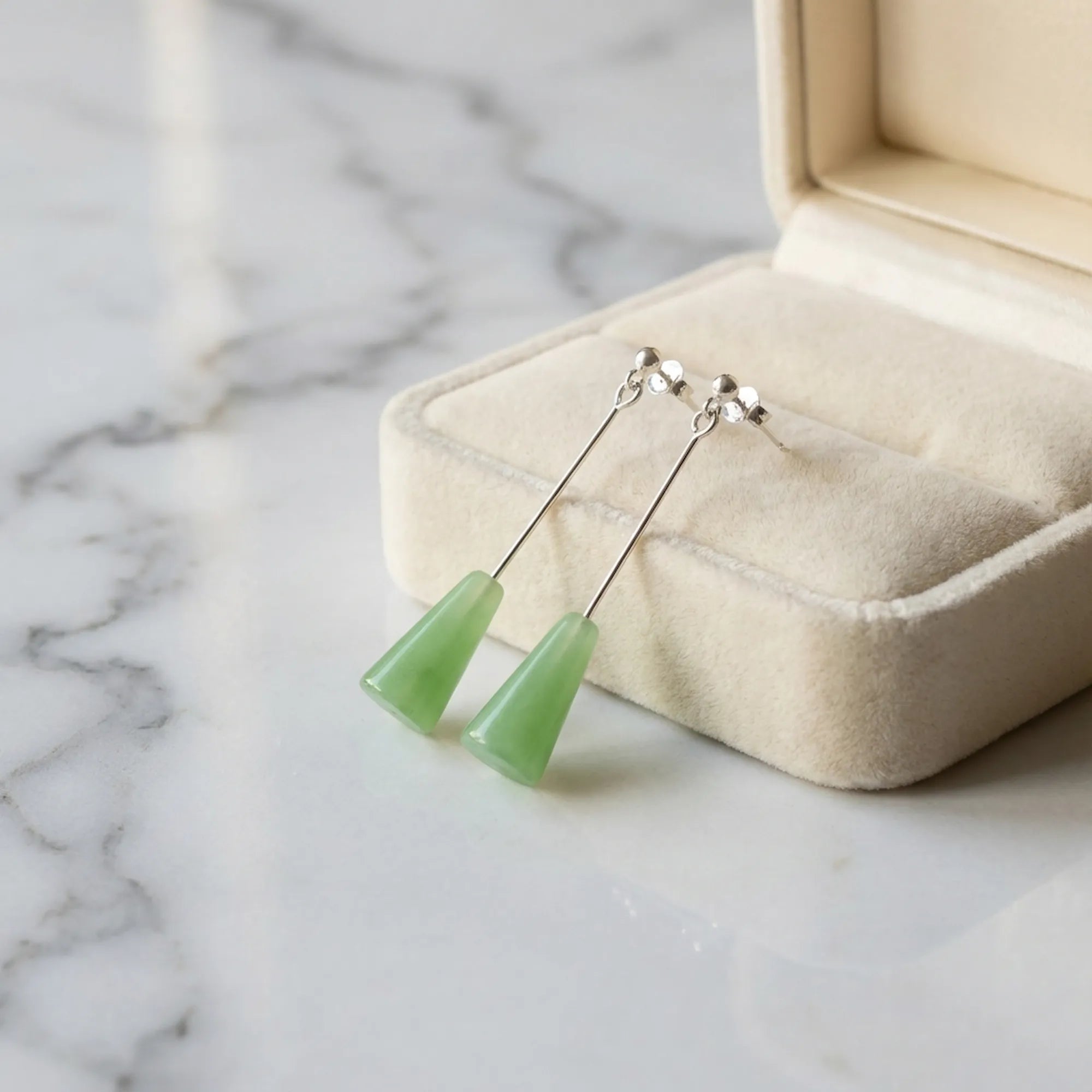 Sage green lucite cone drop earrings in cream velvet jewelry box on marble — minimalist gift earrings Dubai