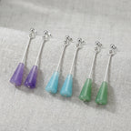 All three lucite cone drop earrings flat lay on linen — amethyst purple, aqua blue, sage green with 925 silver bars